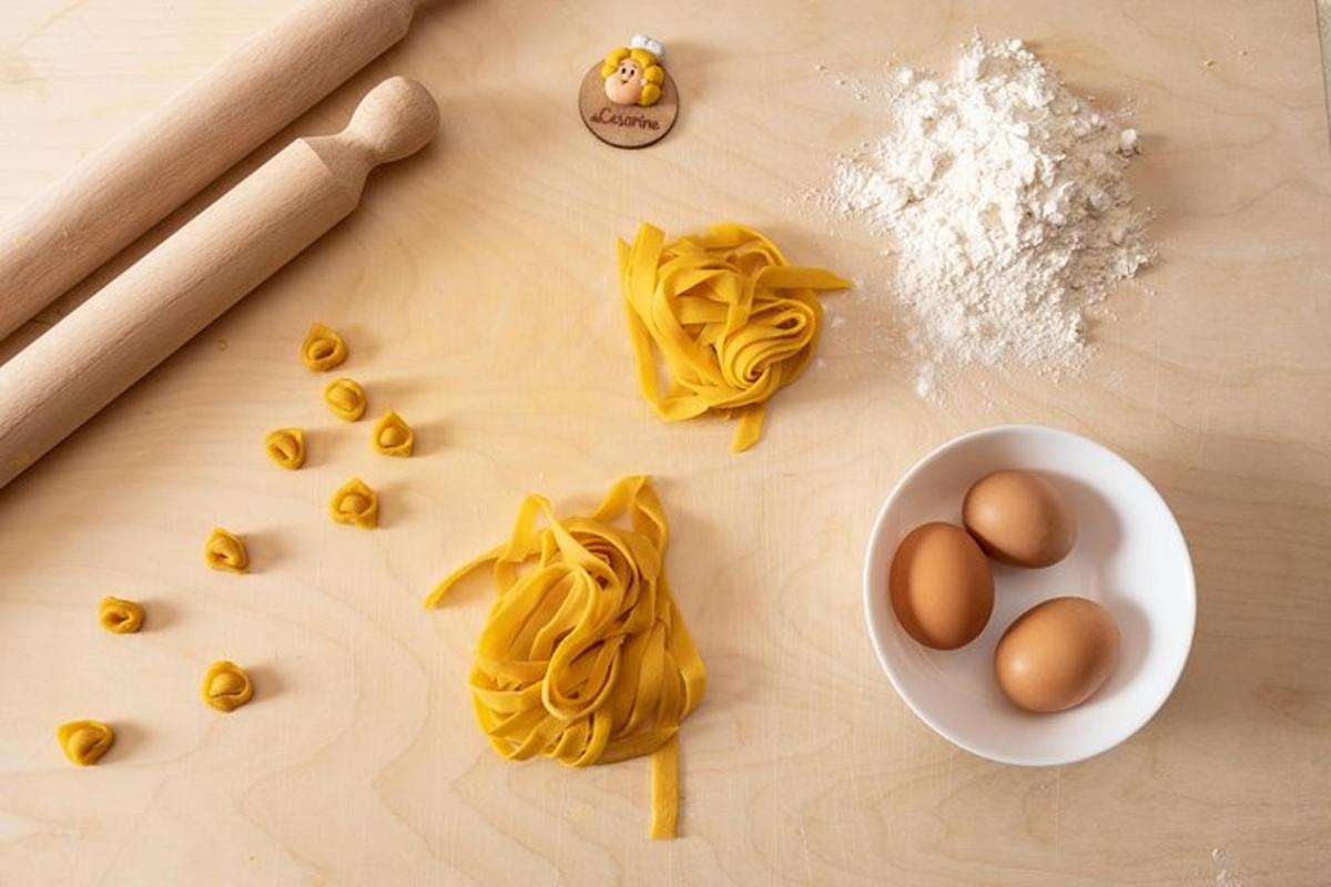 Una tabla de cortar con pasta, huevos y harina.