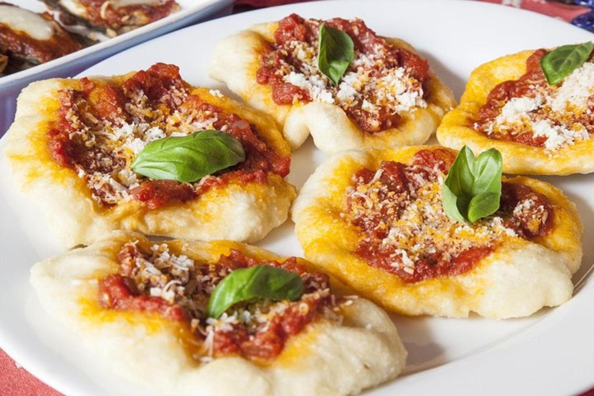 um prato de pizzas pequenas com manjericão por cima