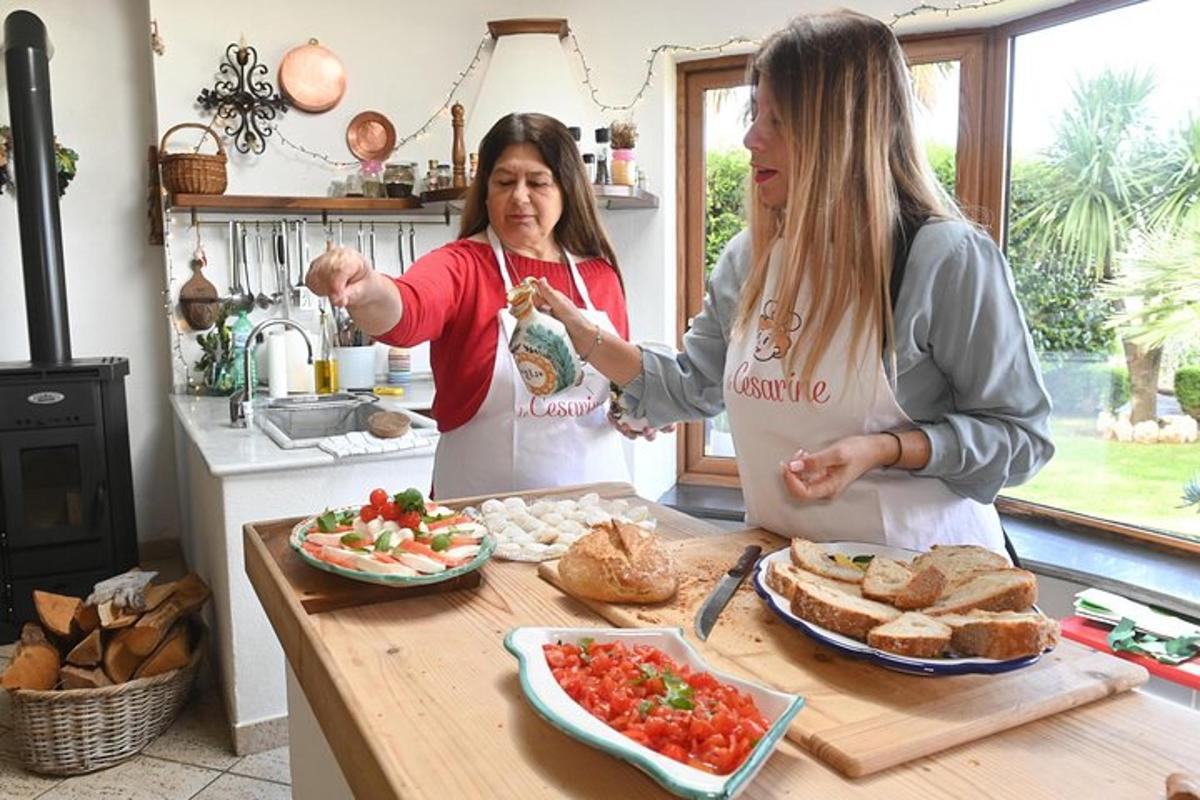 twee vrouwen staan in een keuken en bereiden eten
