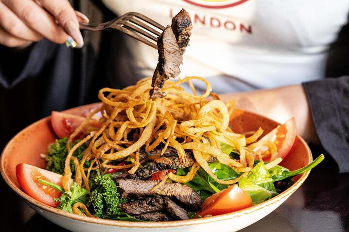 a person eating a bowl of noodles and vegetables