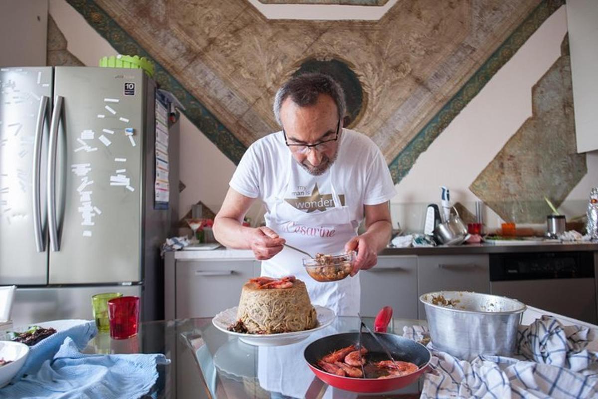 un uomo in piedi in cucina che taglia una torta
