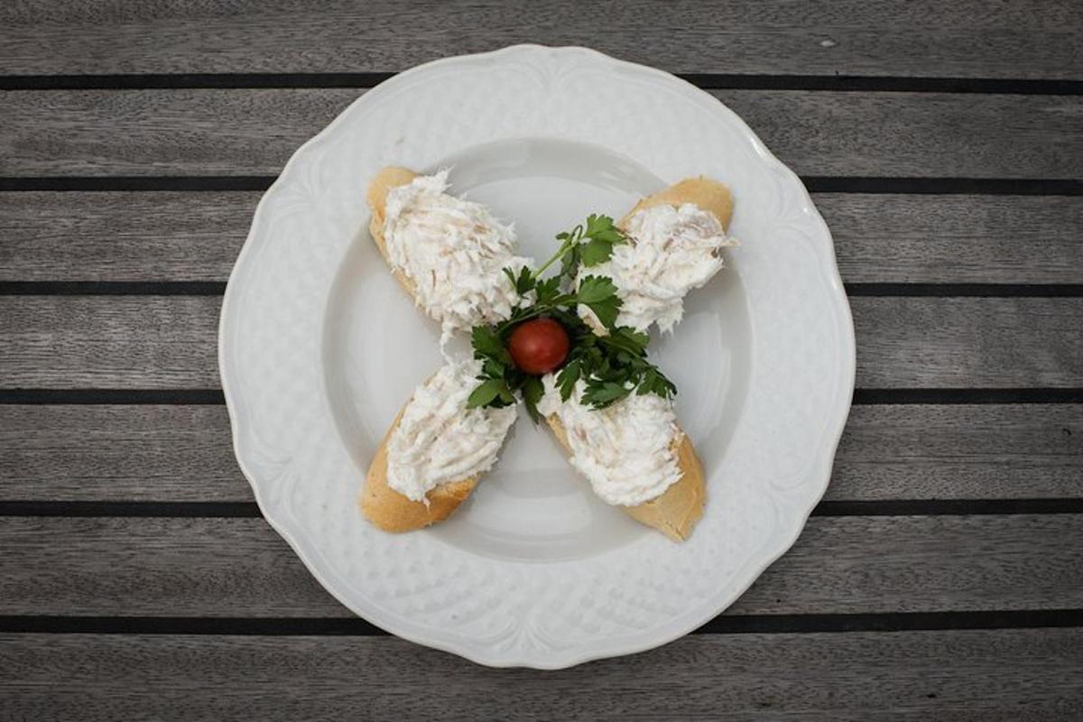 Un plato con dos sándwiches y un tomate encima.