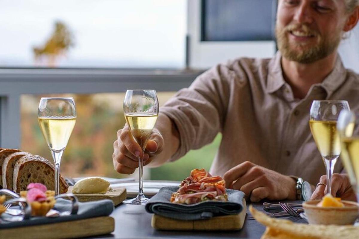 um homem sentado à mesa com duas taças de vinho