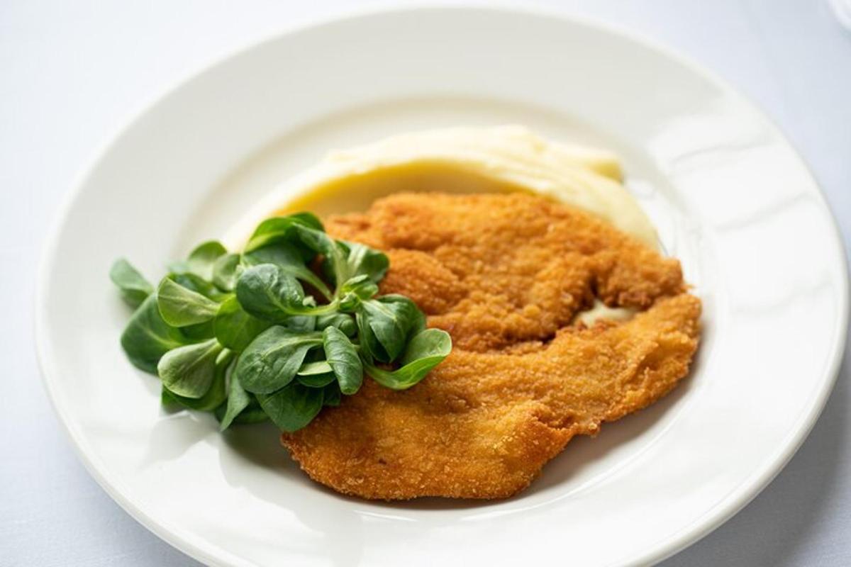 piring putih berisi ayam dengan sayuran dan saus