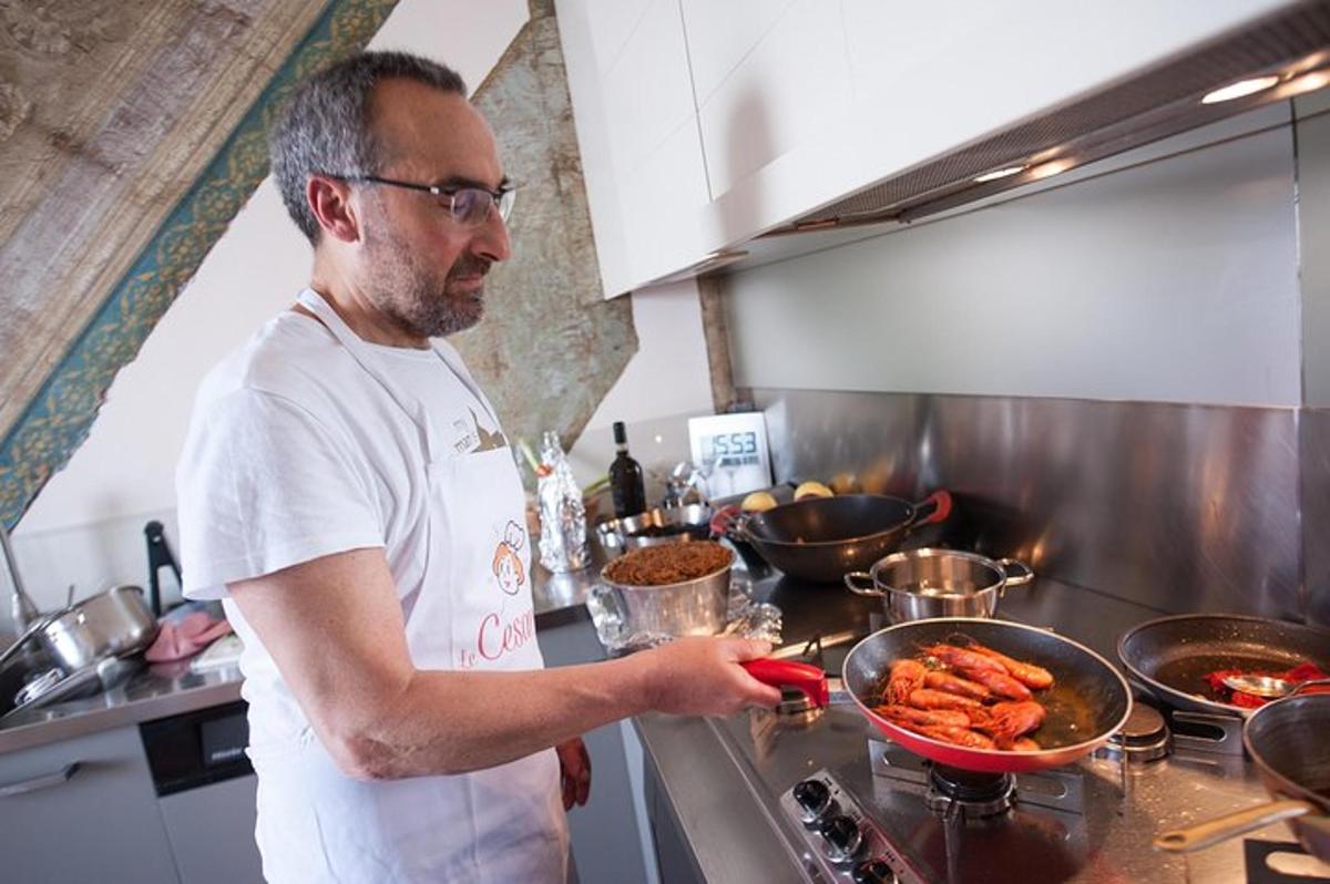egy férfi a konyhában, ételt készít egy serpenyőben