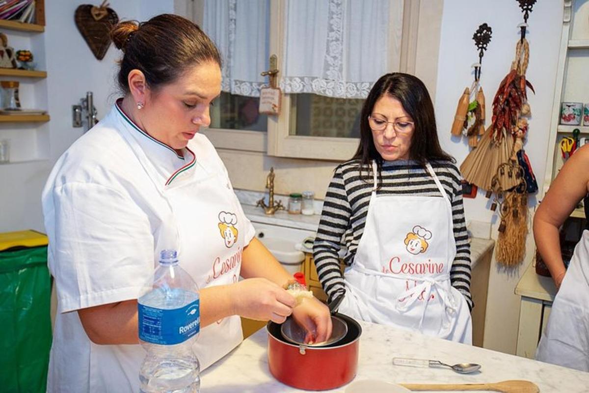 kaks naist köögis potis toitu valmistamas