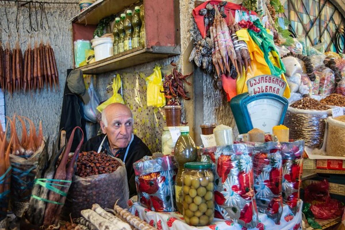 ένας άντρας που κάθεται σε μια αγορά με ένα σωρό τρόφιμα