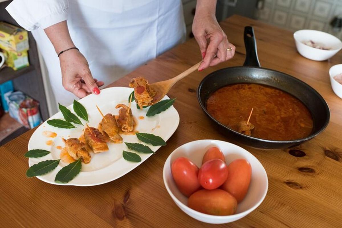 eine Person bereitet Essen auf einem Tisch mit einer Schüssel Tomaten zu