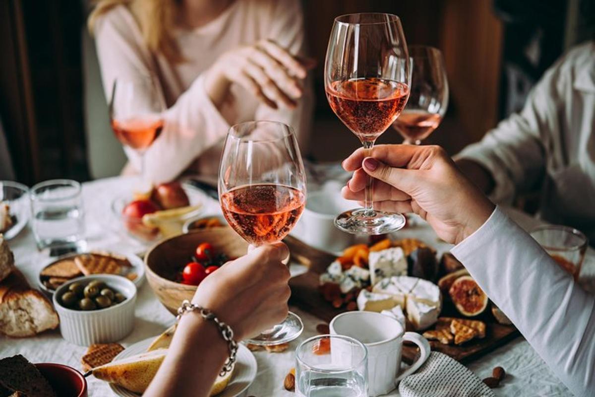 um grupo de pessoas sentadas ao redor de uma mesa bebendo vinho