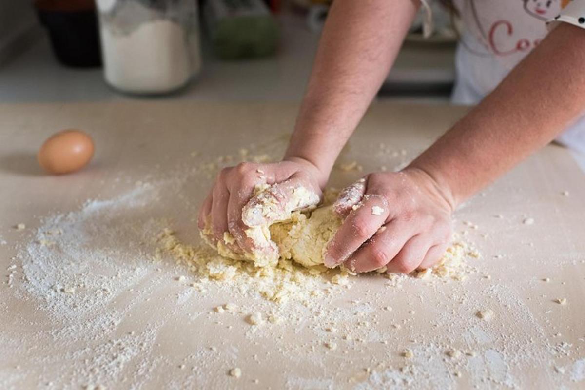 a child is kneading a dough on a counter