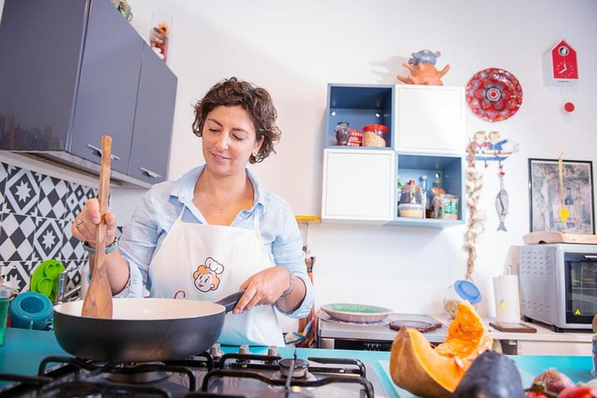 naine köögis pliidil panni segamas