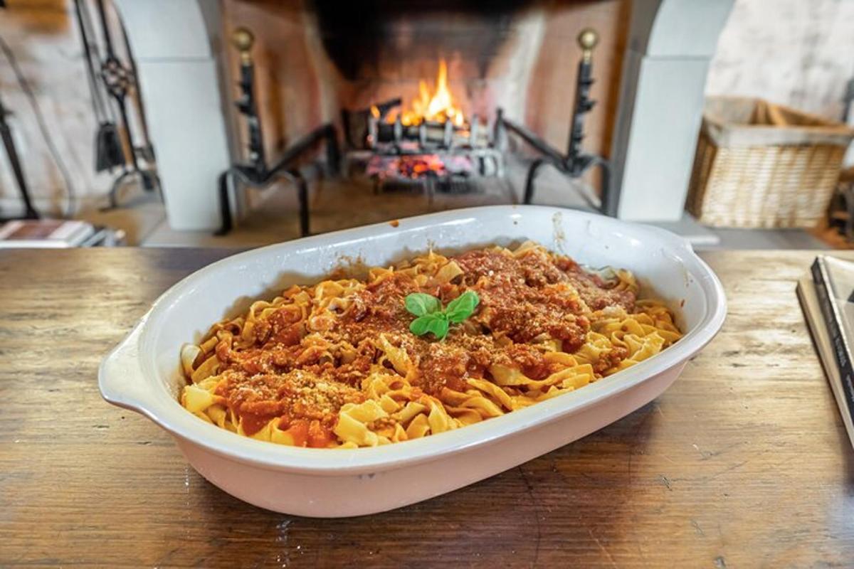 a bowl of pasta on a table with a fireplace