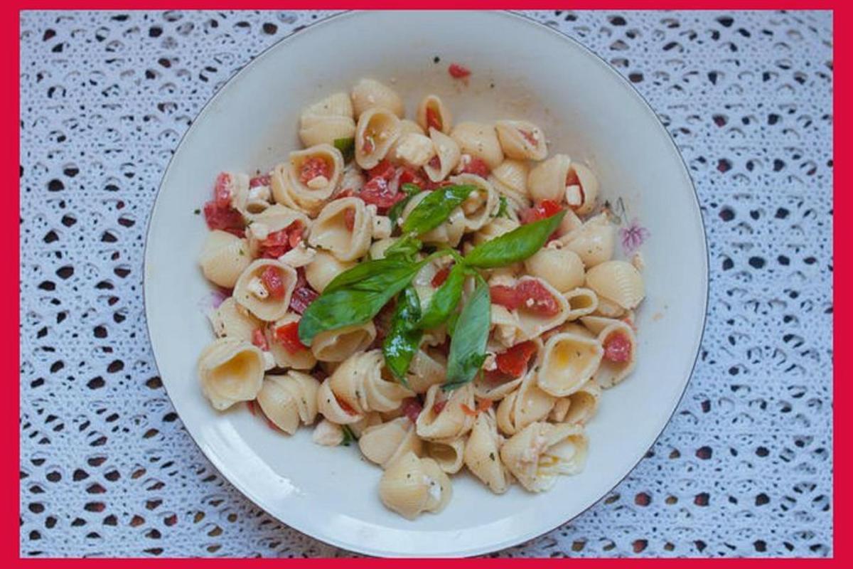 mangkuk putih pasta dengan selasih di atas meja