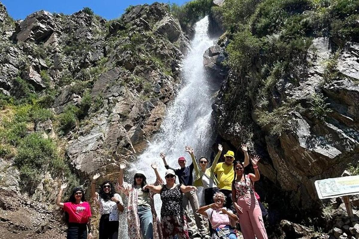 um grupo de pessoas em pé em frente a uma cachoeira