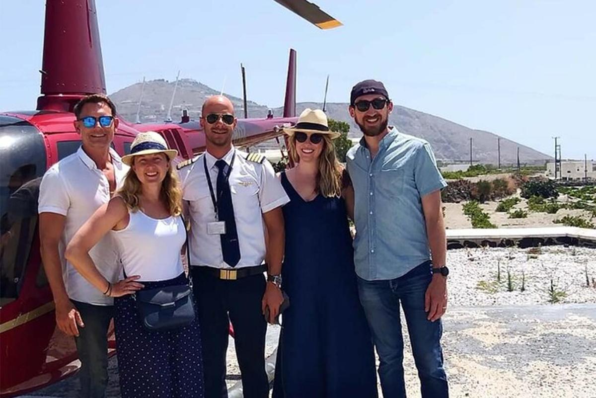 un gruppo di persone in piedi davanti a un elicottero