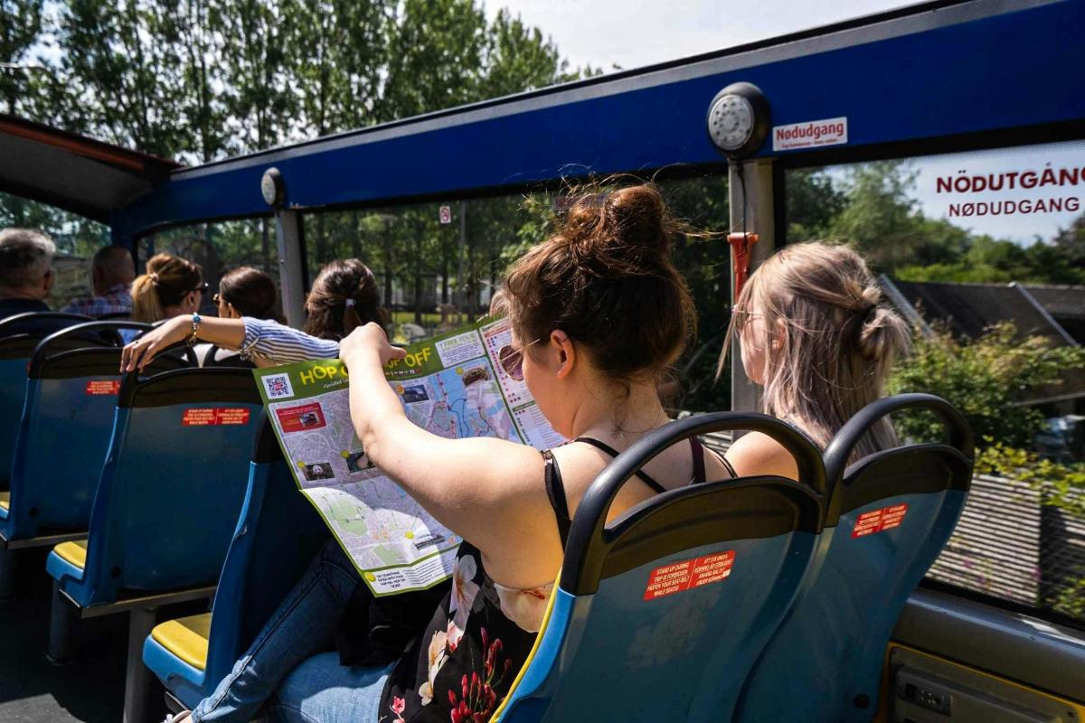 pessoas sentadas em um ônibus olhando para um mapa