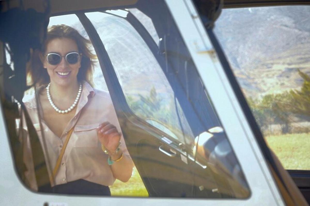 a woman is sitting in a car smiling