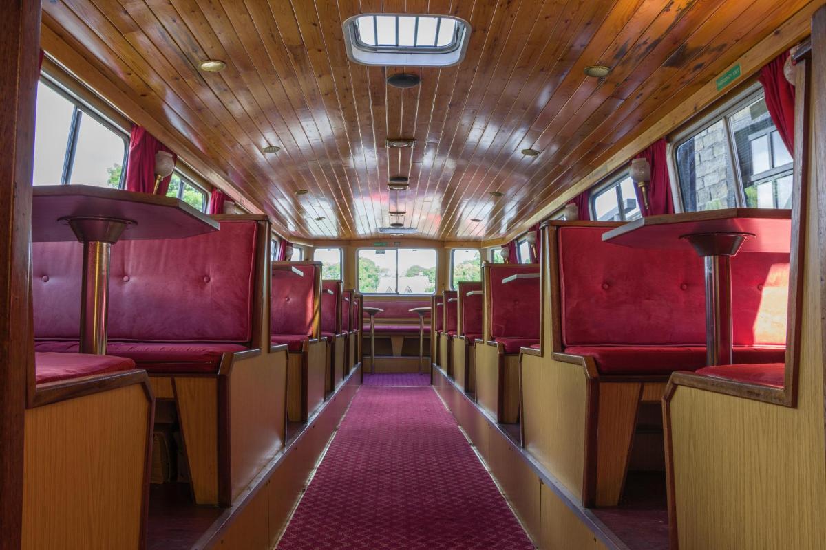 a train car with red seats and a pink carpet