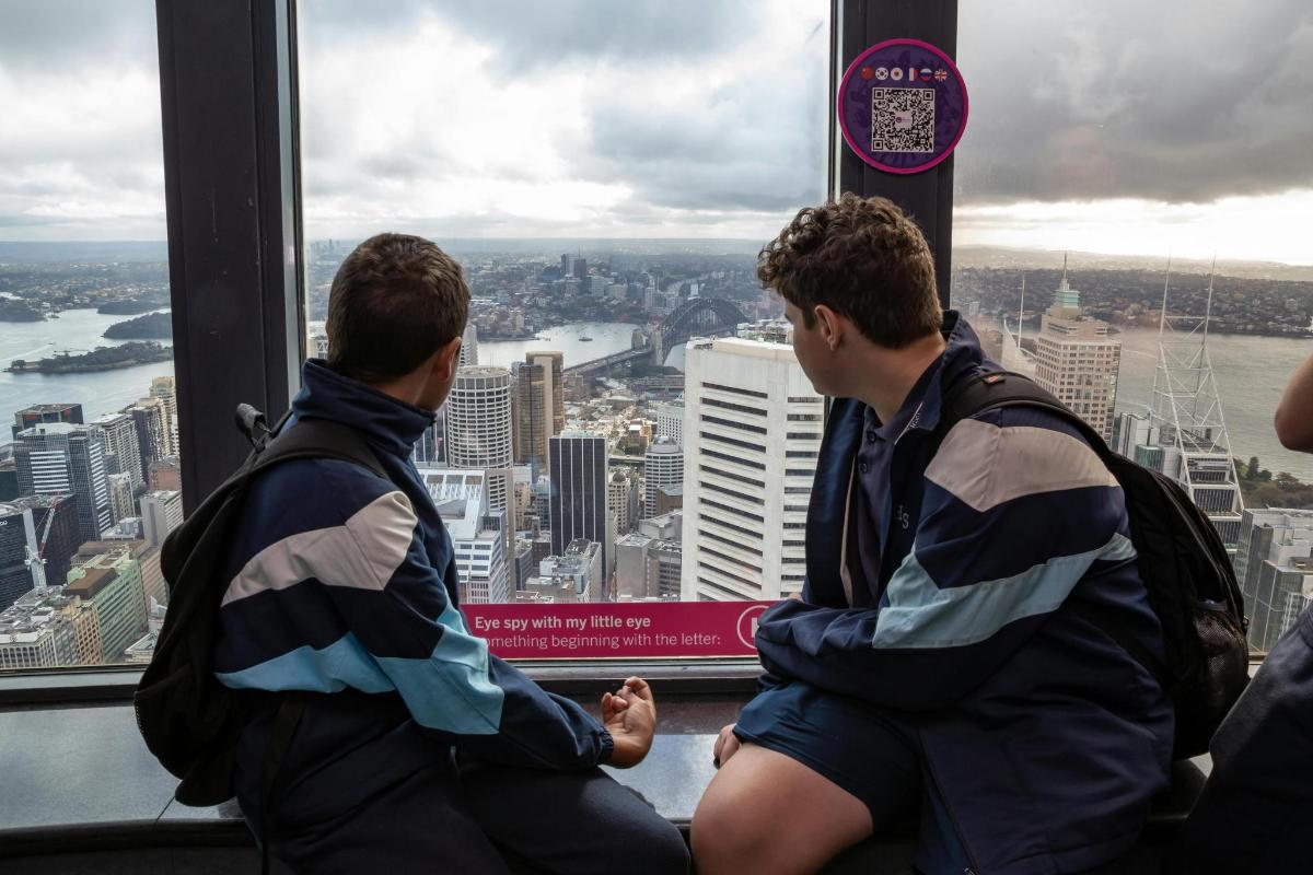 two men sitting in front of a window in a skyscraper