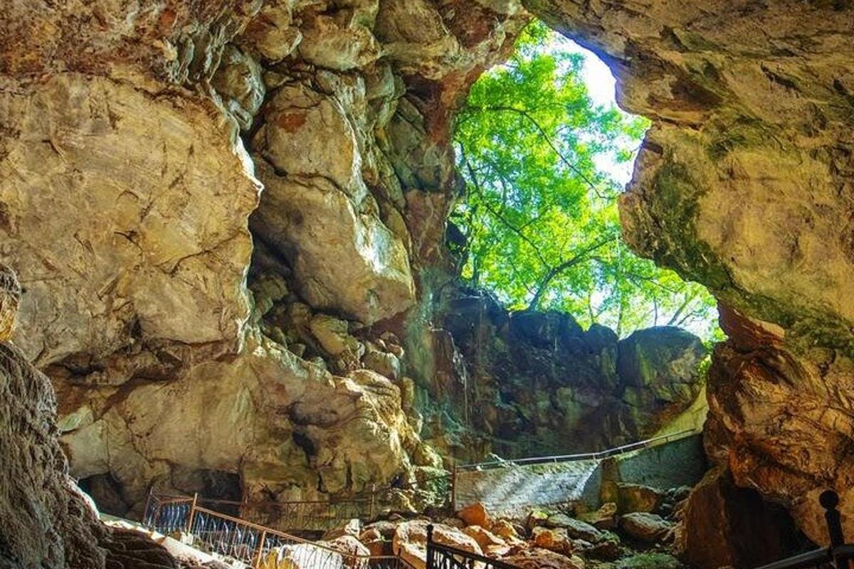a cave in a rocky mountain with a bridge in it