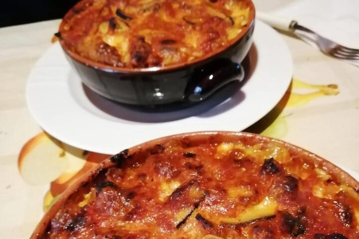 Tveir réttir af mat á hvítum diski með pizzu