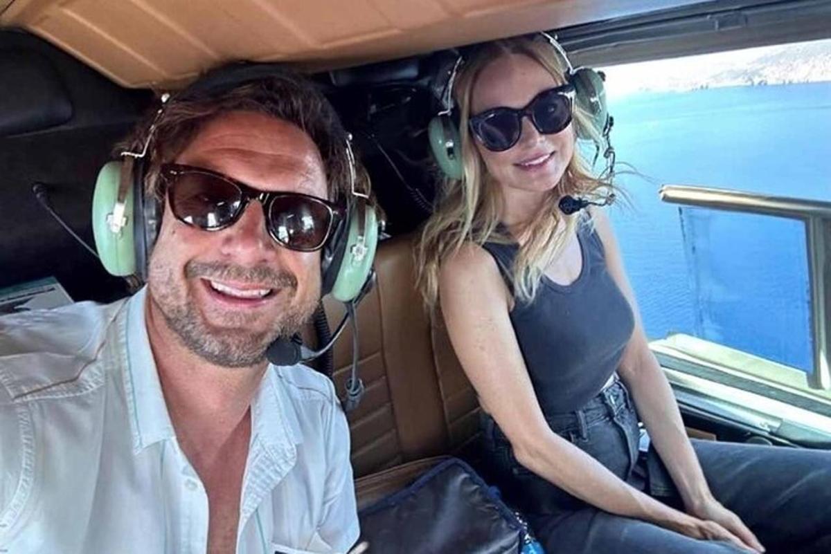 Un hombre y una mujer sentados en un coche con auriculares.