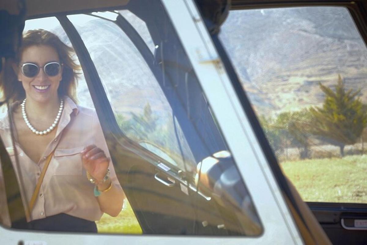Una mujer está sentada en un coche sonriendo