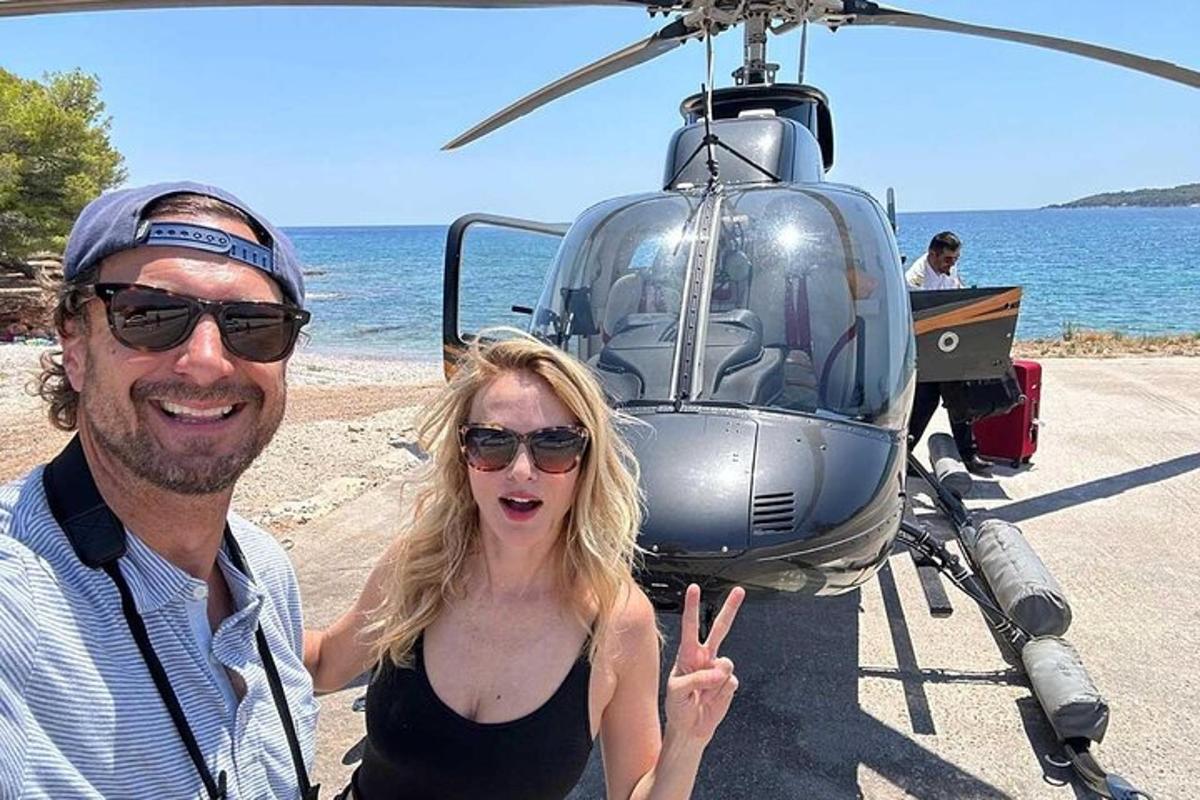 seorang lelaki dan wanita berdiri di hadapan sebuah helikopter