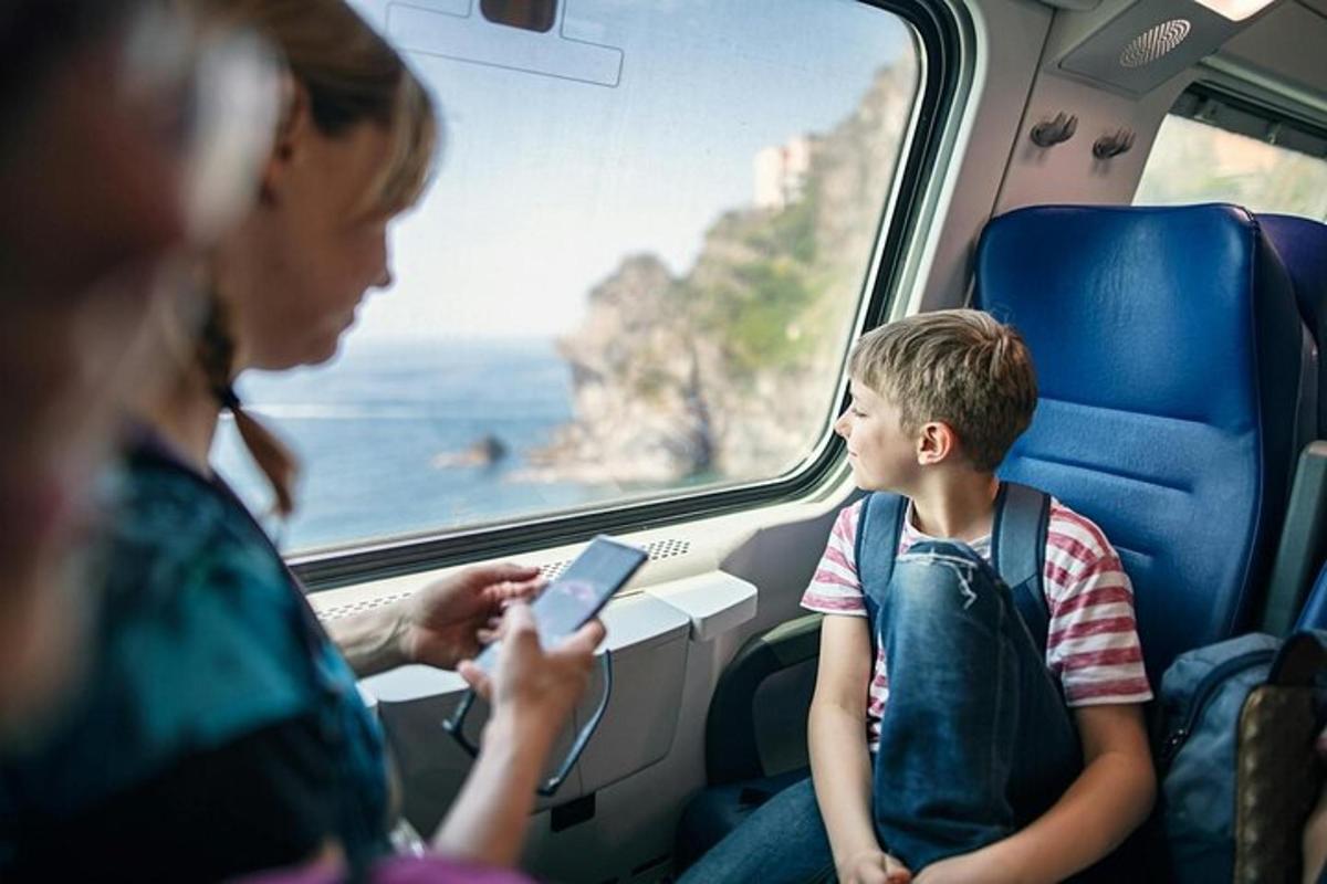 eine Frau und ein Junge sitzen in einem Zug und schauen auf ein Mobiltelefon