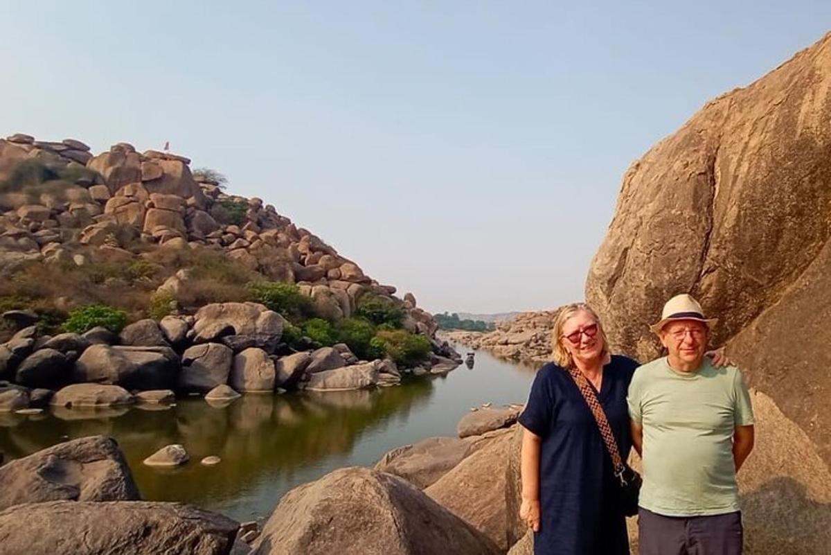 a man and woman standing next to a river