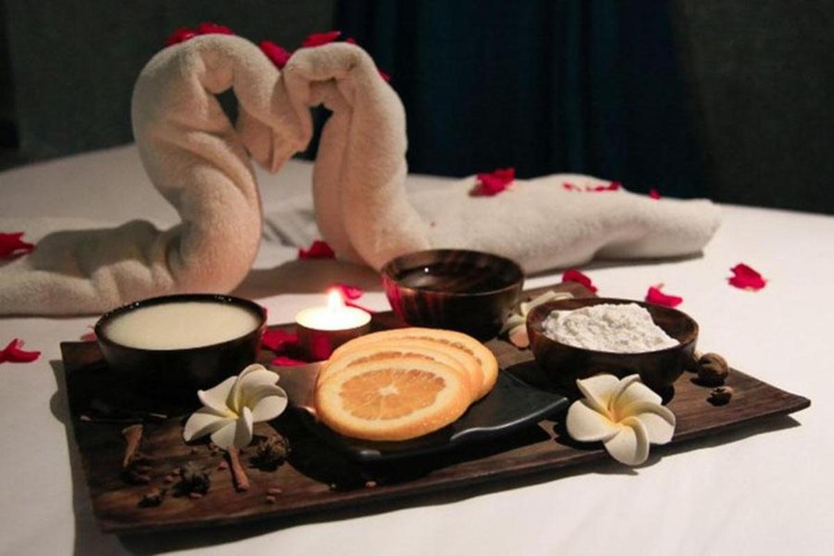 một khay thức ăn với cơm và hai con hồng hạc và nến