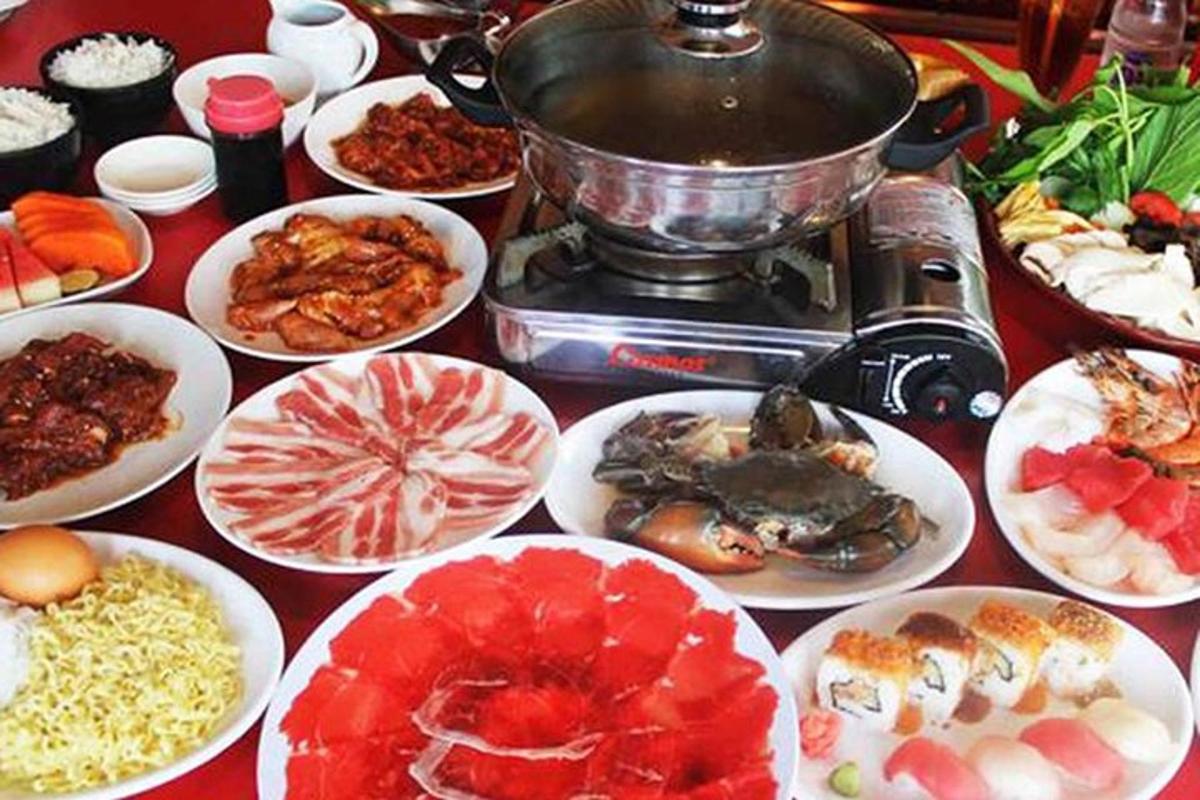 meja yang dipenuhi piring makanan dan panggangan