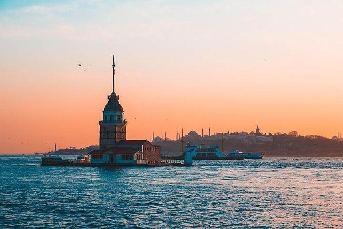 un edificio con una torre nell'acqua al tramonto