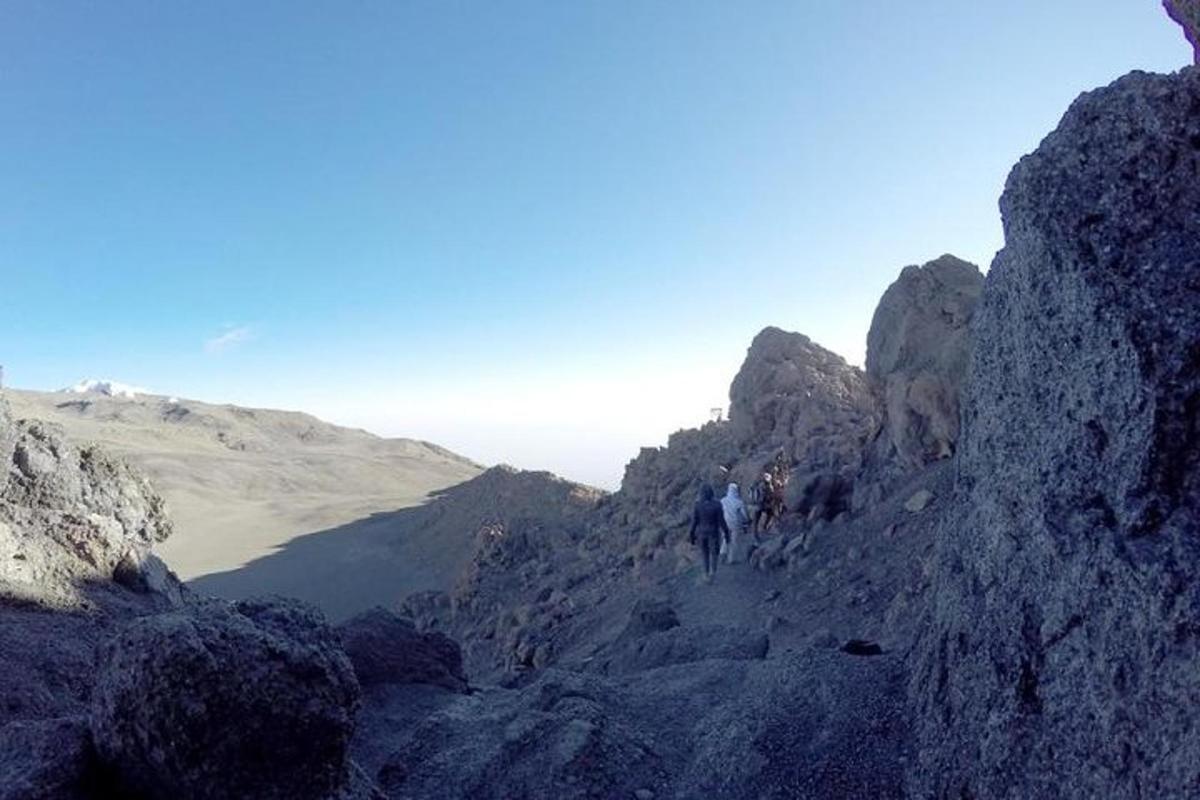 a group of people walking on a rocky mountain