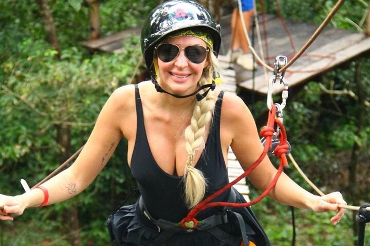 žena v helmě a slunečních brýlích na zip line