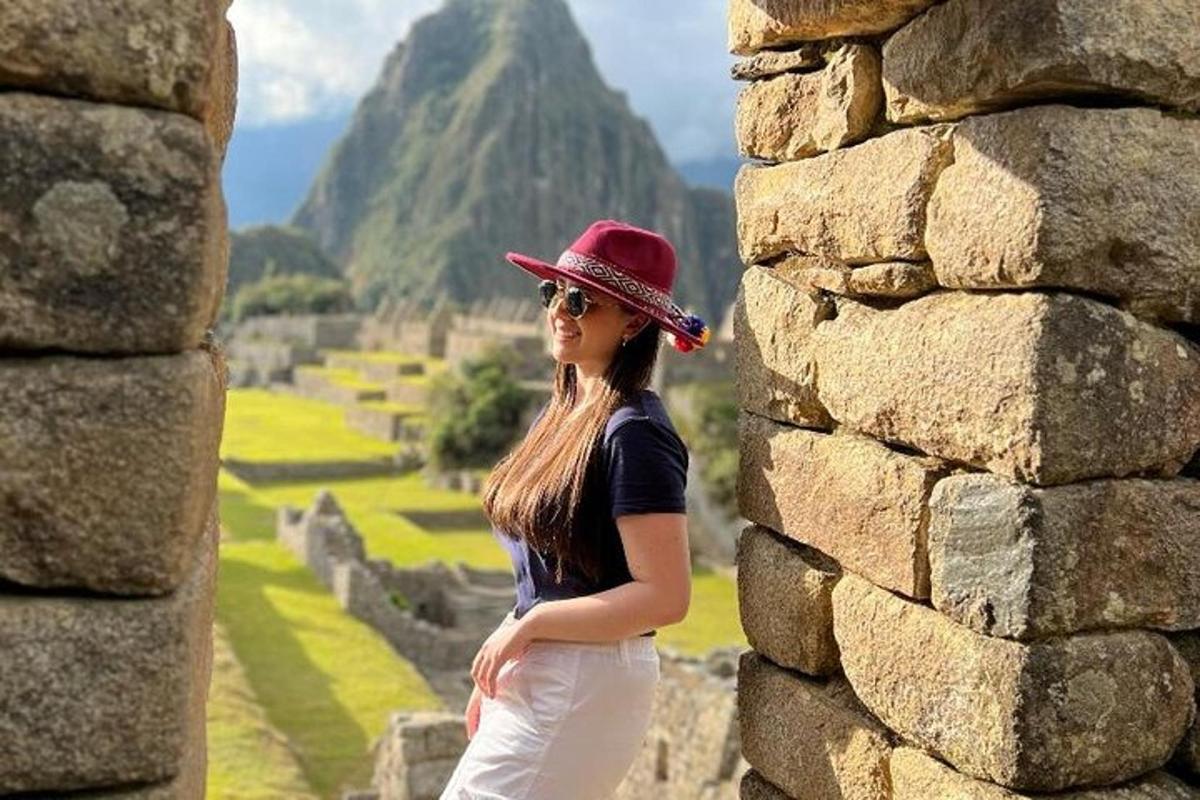 una donna che indossa un cappello rosso in piedi davanti a un muro di pietra