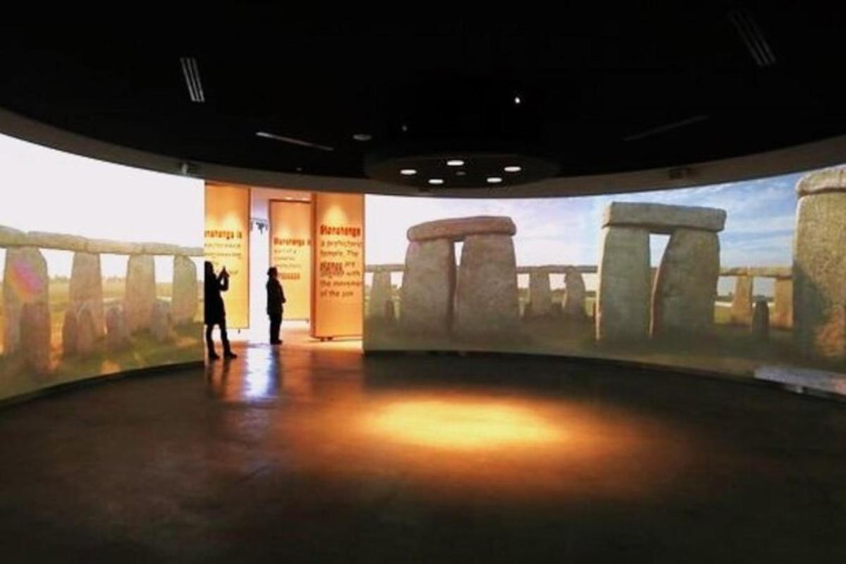un grup de persones dretes en un museu amb una gran pintura