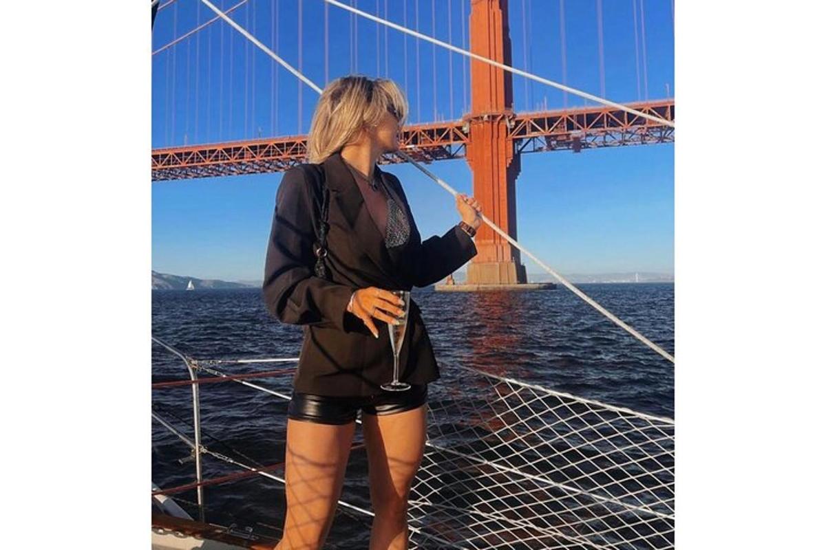 una dona dreta en un vaixell davant d'un pont