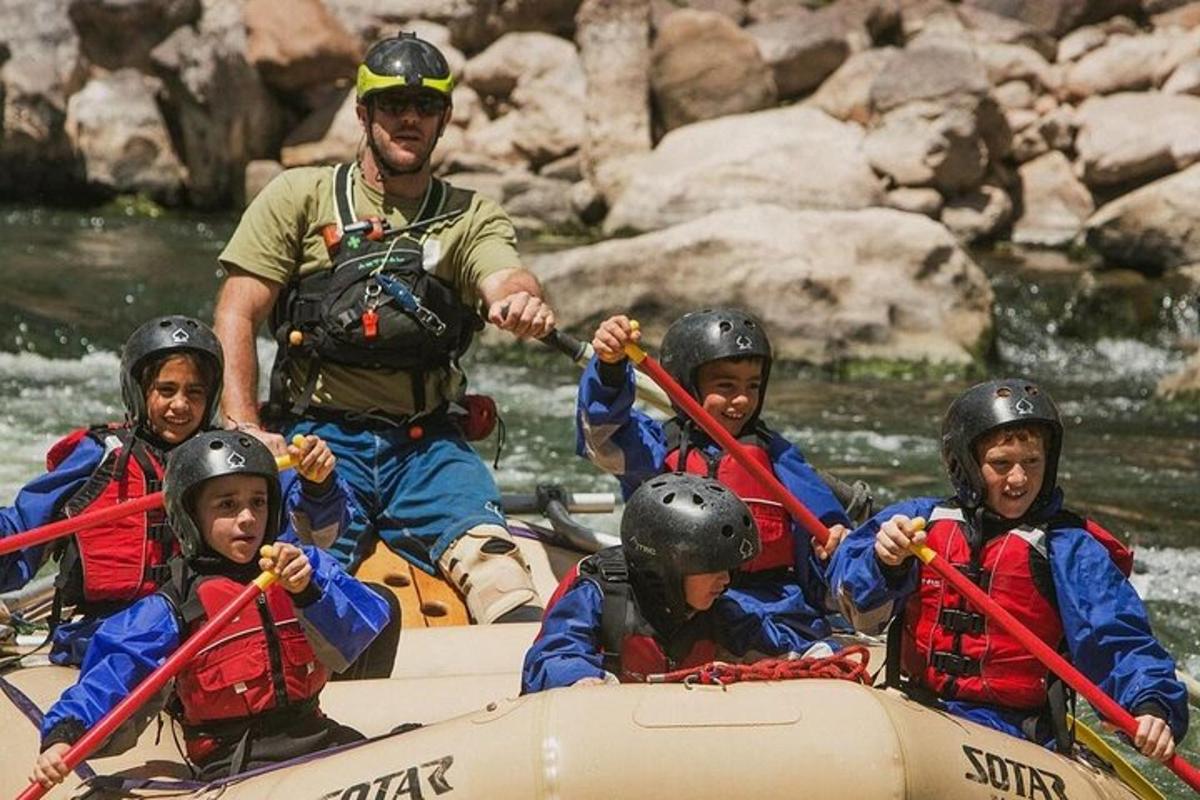 un uomo e un gruppo di bambini su una zattera su un fiume