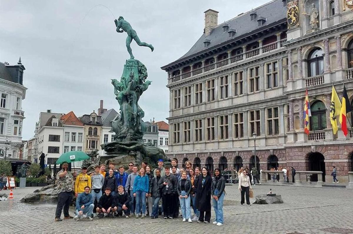 Un grupo de personas de pie frente a una estatua