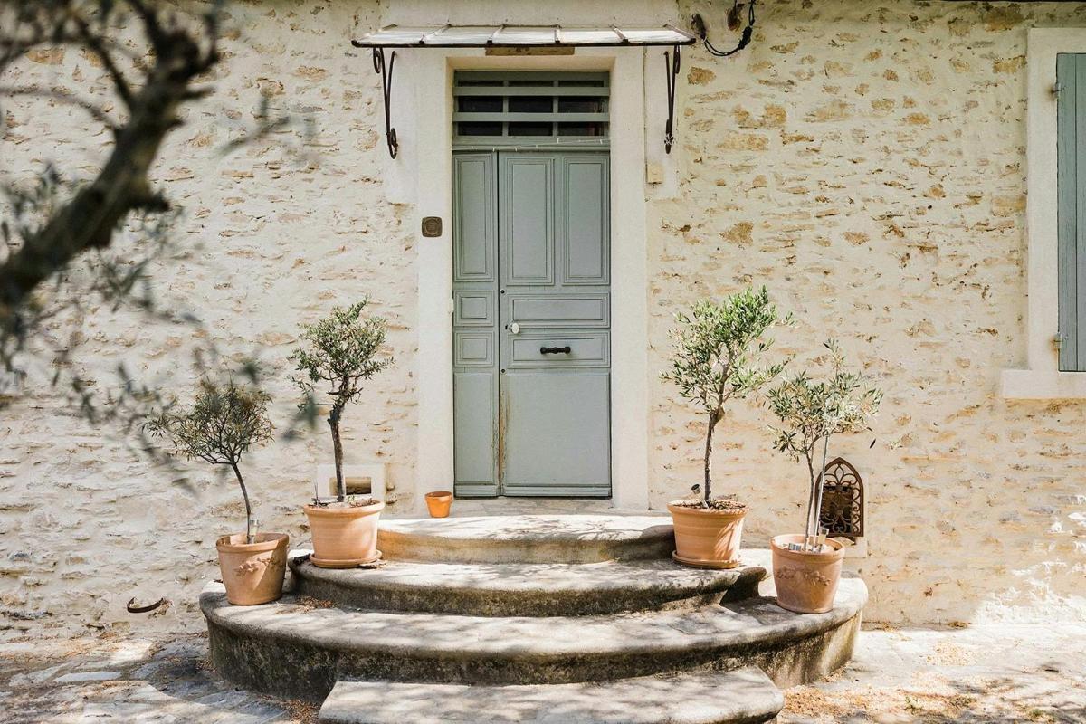 a house with a blue door and some potted plants