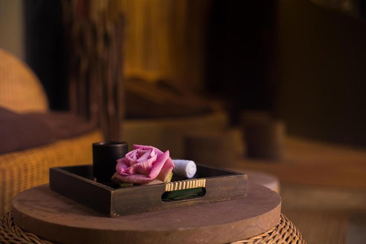eine schwarze Schachtel mit einer rosa Blume und einem Pinsel