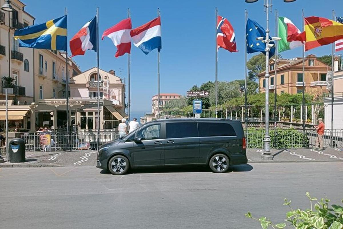 zelen kombi parkiran na parkirišču z zastavami