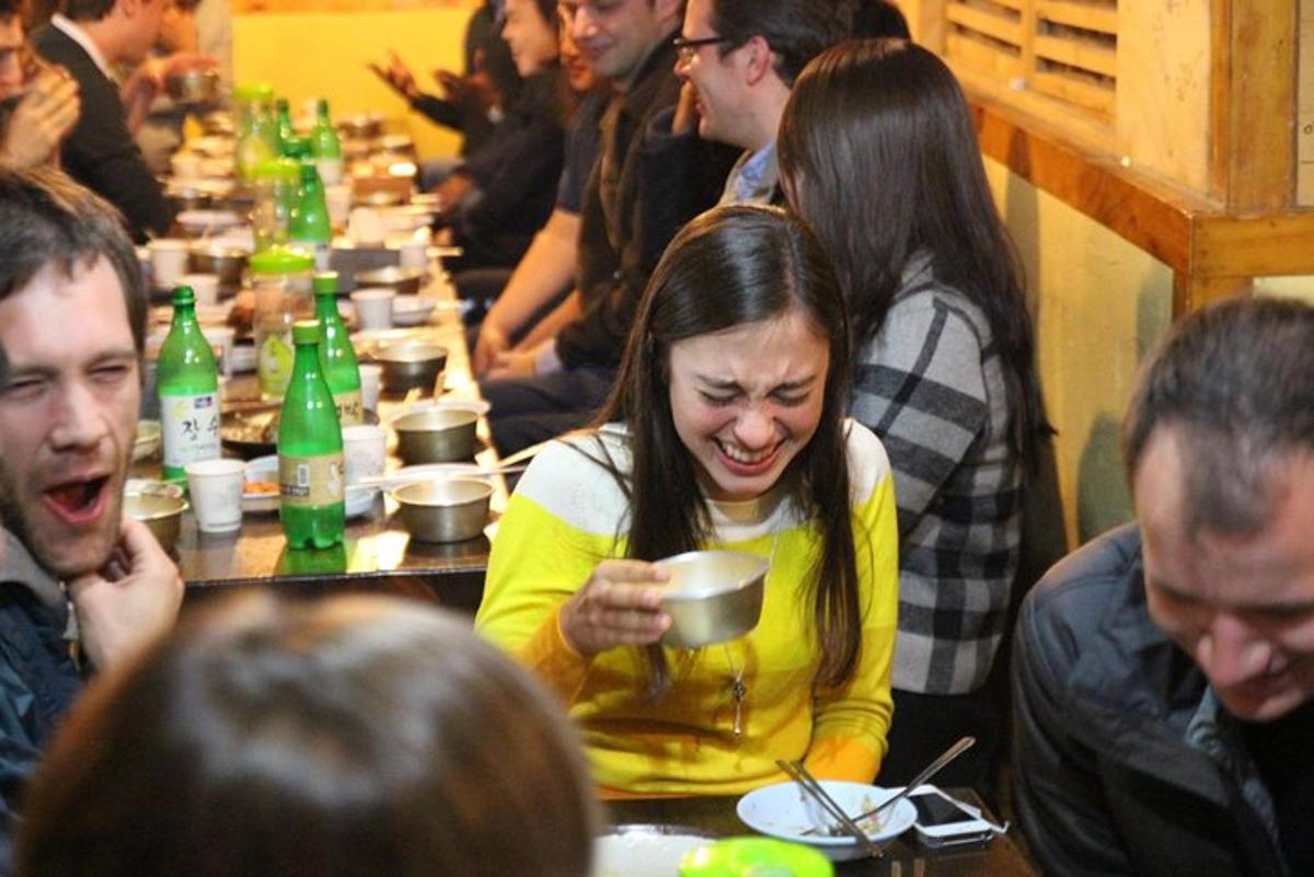 un gruppo di persone sedute a un tavolo che mangiano