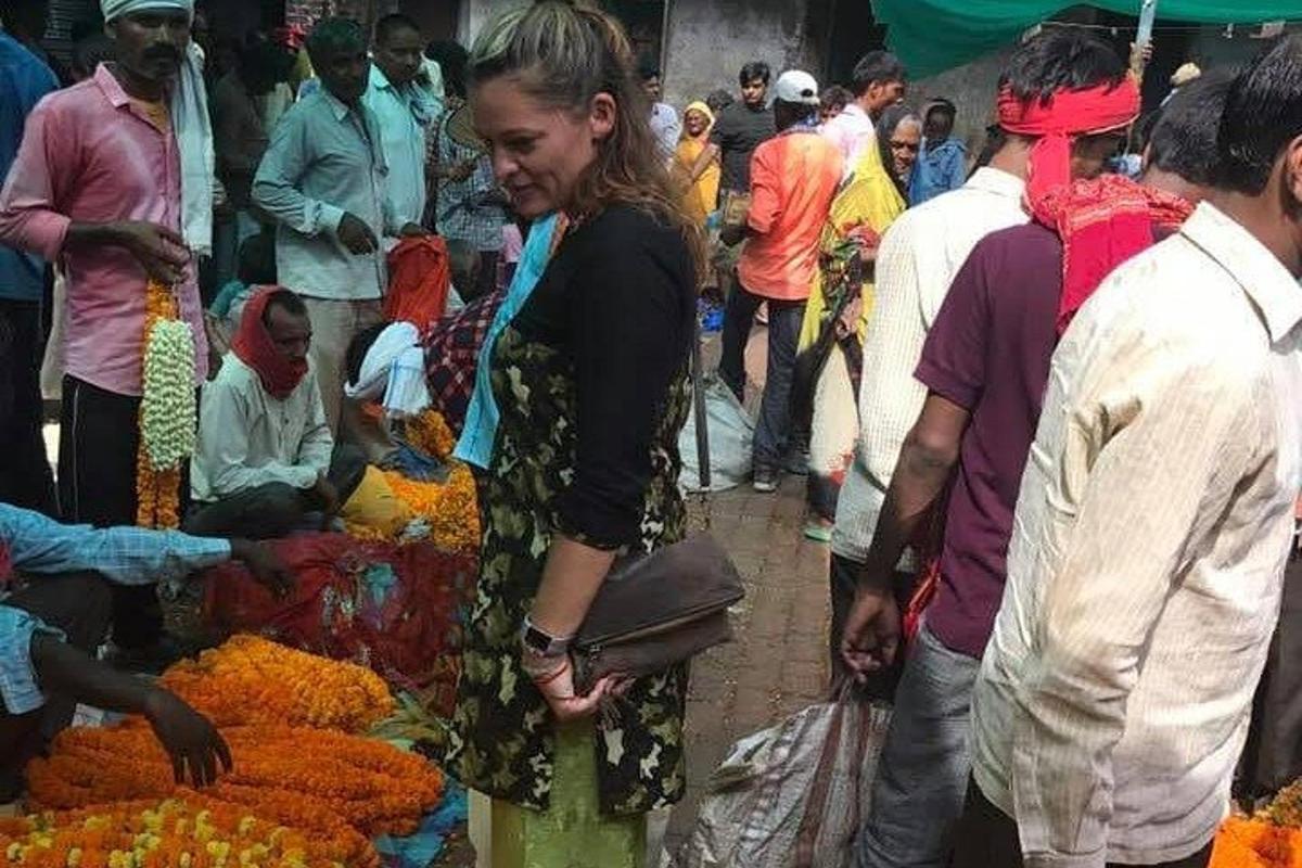 seorang wanita berdiri di pasar dengan sekumpulan orang