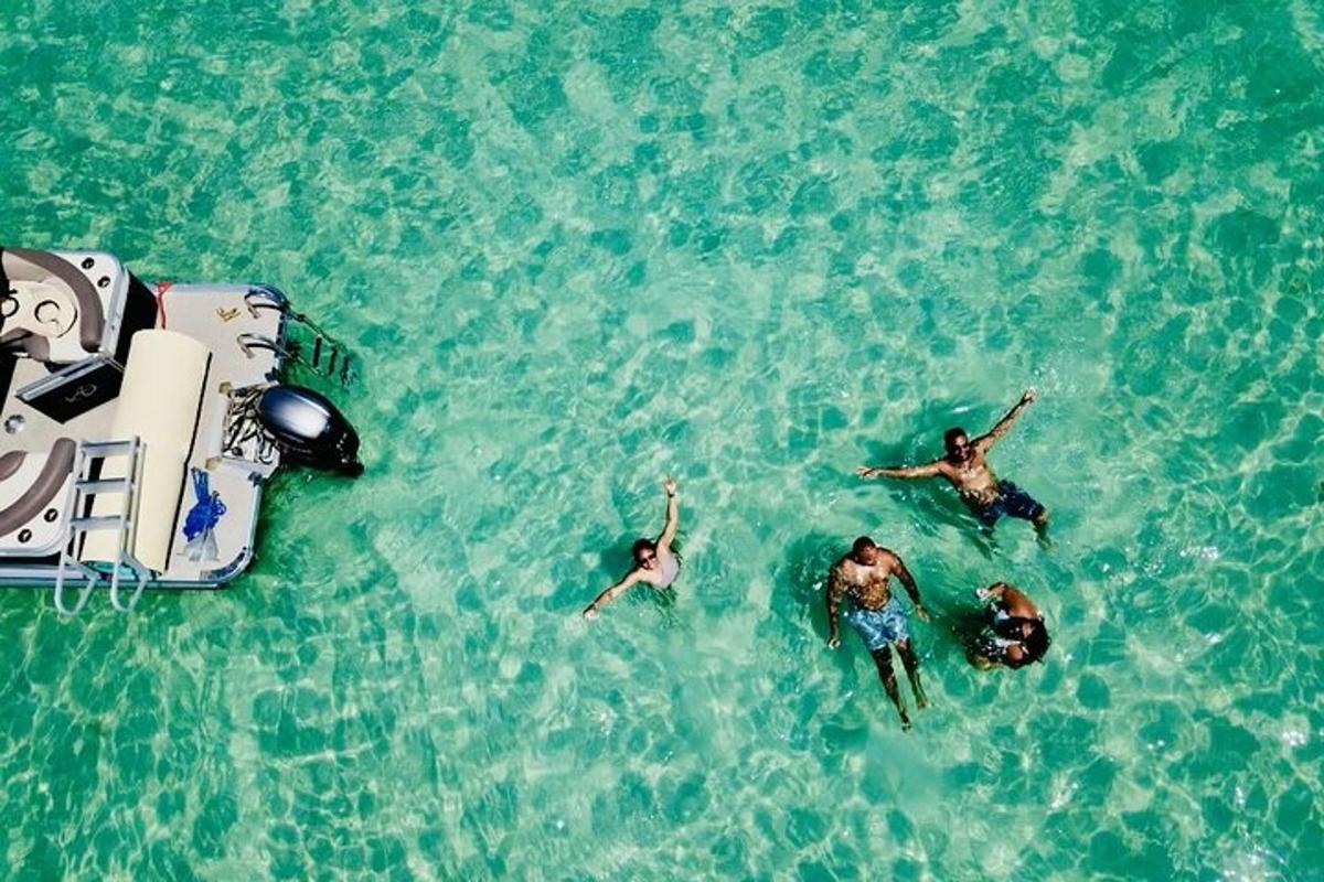 três pessoas nadando na água ao lado de um barco