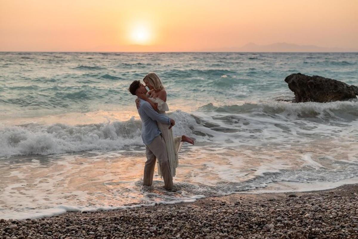 un uomo e una donna in piedi sulla spiaggia con l'oceano