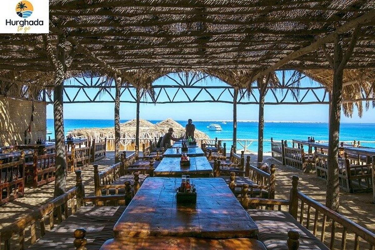 a row of tables on a beach with the ocean