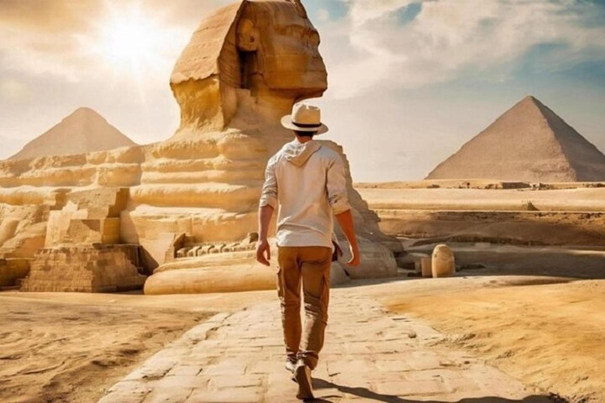 a man walking in front of the pyramids