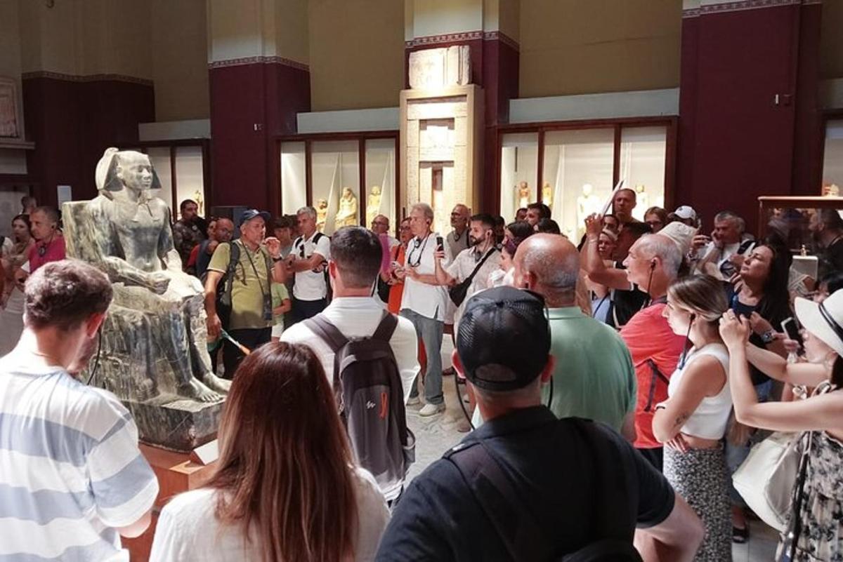 a crowd of people looking at a statue in a museum